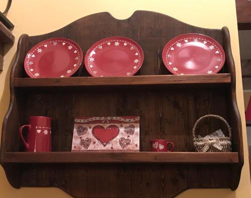 a wooden shelf with plates and cups and a basket at Casa vacanze romantica in San Giacomo