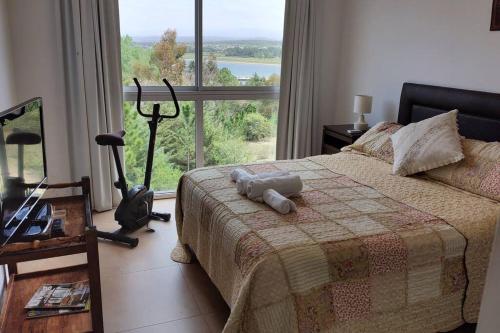 1 dormitorio con cama y ventana grande en Condominio Monte Molinos - Departamento en Náutico frente al Lago en Villa Ciudad de América