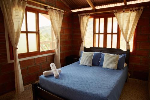 a bedroom with a bed with a teddy bear on it at Finca Hotel Betel in San Carlos