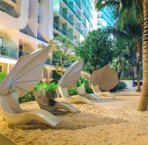 a row of chairs and umbrellas on a beach at AZURE Urban Resort Residences Condominium in Manila