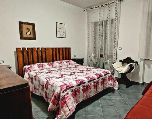 Schlafzimmer mit einem Bett mit einer roten und weißen Decke in der Unterkunft Roxy Alto Belvedere in Casale la Cogna