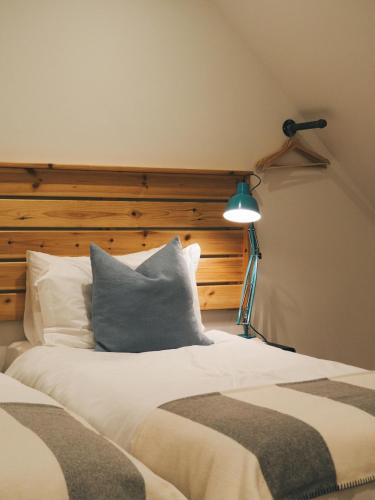 a bedroom with a bed with a headboard and a lamp at The Trossachs Collection in Kepculloch