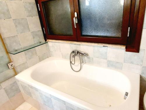 a bath tub with a faucet in a bathroom at La Mansardina in Casale la Cogna