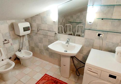 a bathroom with a sink and a toilet at La Mansardina in Casale la Cogna