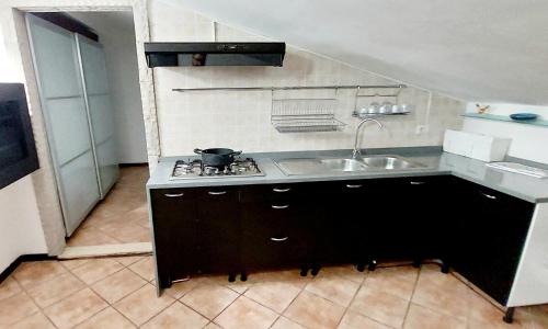 a small kitchen with a sink and a stove at La Mansardina in Casale la Cogna