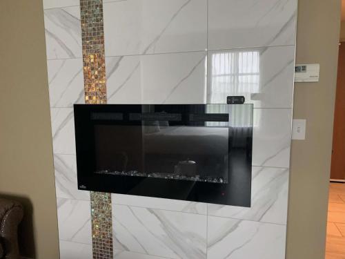 a living room with a wall with a fireplace at Best Western Plus St. John's Airport Hotel and Suites in St. John's