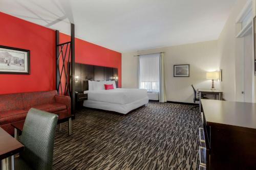 a hotel room with a bed and a red wall at C Hotel by Carmen's, BW Premier Collection in Hamilton
