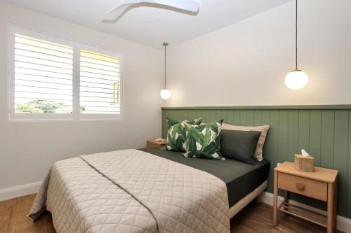 ein Schlafzimmer mit einem Bett und zwei Fenstern in der Unterkunft Aquarius Apartment 9 in Hawks Nest