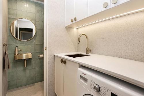 ein Bad mit einem Waschbecken und einem Spiegel in der Unterkunft Aquarius Apartment 9 in Hawks Nest