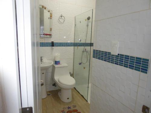 La salle de bains est pourvue de toilettes et d'une douche en verre. dans l'établissement CortLang - Beach Apartments - in El Pueblito near Playa Dorada, à San Felipe de Puerto Plata