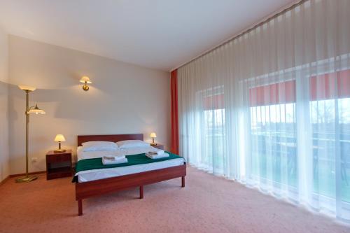 a bedroom with a bed and a large window at Hotel Kameralny in Kielce