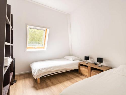 Cette chambre blanche dispose de deux lits et d'une fenêtre. dans l'établissement Charming holiday home in Poortugaal with garden, à Poortugaal