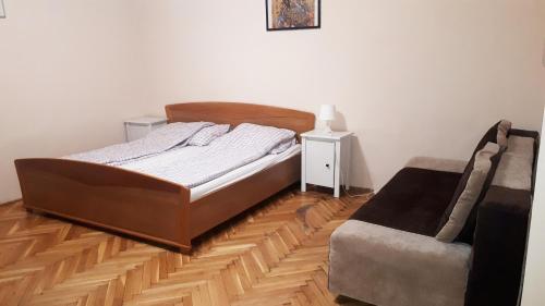 een slaapkamer met een bed en een stoel bij Garibaldi Apartman in Boedapest