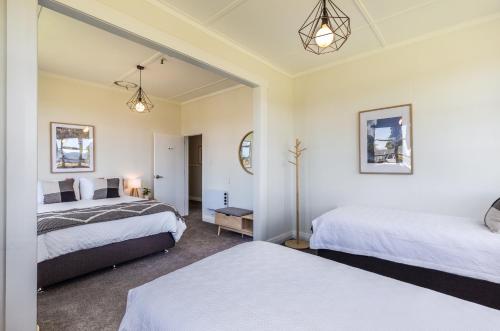 a bedroom with two beds and a mirror at Lake Maraetai Lodge in Mangakino