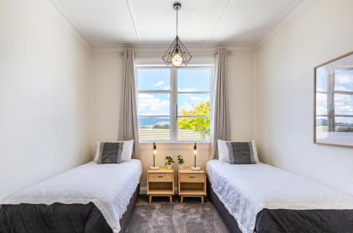2 Betten in einem Zimmer mit Fenster in der Unterkunft Lake Maraetai Lodge in Mangakino