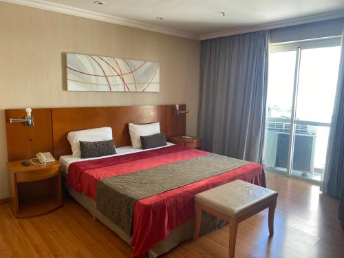 1 dormitorio con 1 cama grande con manta roja en Apart hotel Barra First, en Río de Janeiro