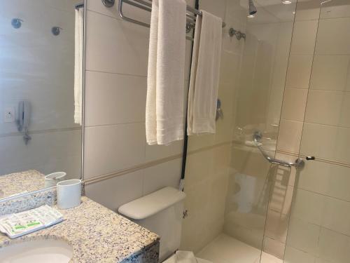 y baño con ducha, aseo y lavamanos. en Apart hotel Barra First, en Río de Janeiro