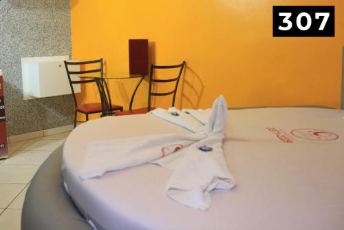 dos toallas blancas sentadas encima de una cama en Hotel l Motel 1001 Noites - Ceilândia, en Brasilia