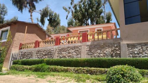 Casa con pared de piedra y balcón en Paqariy lodge, en Ocosuyo