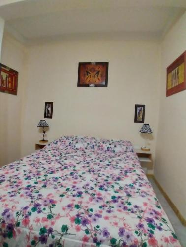 Un dormitorio con una cama grande con flores. en El Faro en Ushuaia