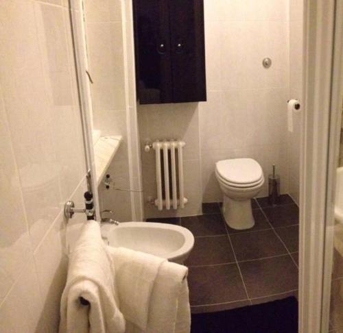 a bathroom with a toilet and a sink with towels at B&B Rome For You in Rome