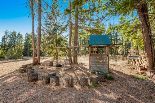 a playground in the woods with a small building at Log Into Vacation Mode in Ronald
