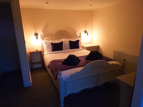 - une chambre dotée d'un lit blanc avec deux sacs dans l'établissement Top Hill Farm Cottage, à Sheffield