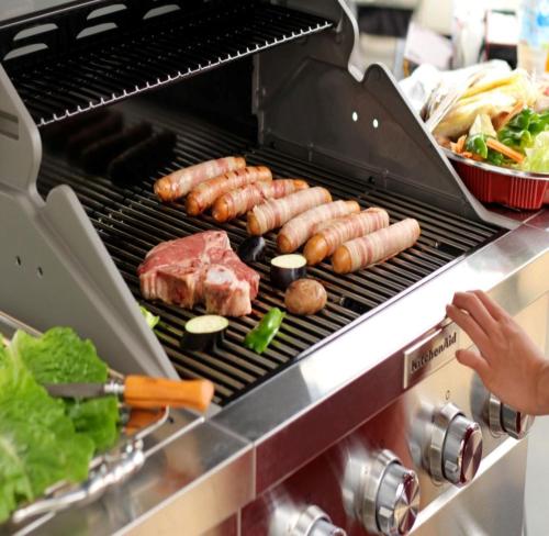 a grill with sausages meat and vegetables on it at オーシャンリゾートshimaoドリームbeach in Himi