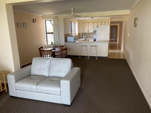 un soggiorno con divano bianco e una cucina di Horizons Unit 2 Beachfront Unit a Bargara