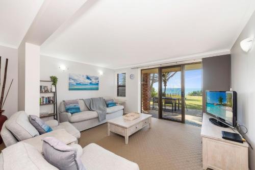 a living room with a couch and a tv at Horizons 1 in Bargara