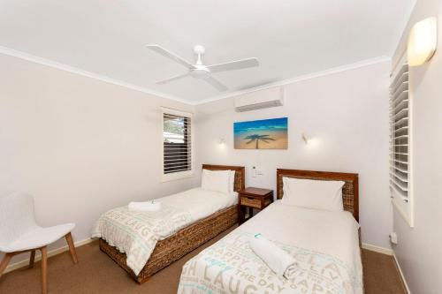 a twin bedroom with two beds and a chair at Horizons 1 in Bargara