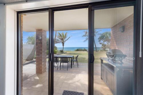 a sliding glass door leading to a patio with a table at Horizons 1 in Bargara