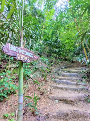a sign in the middle of a trail in the woods at Magdalena Beach House in Los Naranjos