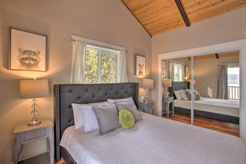 1 dormitorio con 1 cama grande y espejo en Hillside Home with Dock about 8 Mi to Coeur dAlene!, en Hayden Lake