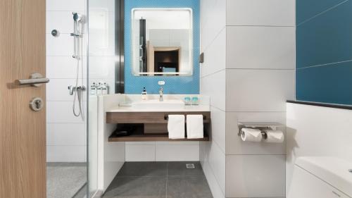 a bathroom with a sink and a mirror at Holiday Inn Express Changsha University Tech City, an IHG Hotel in Changsha