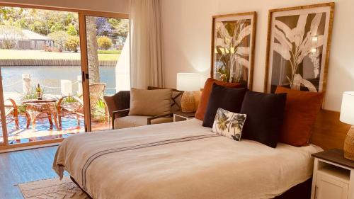 a bedroom with a bed with a view of a patio at Beachside Resort Lagoon Rooms with Garden Patio in Coffs Harbour