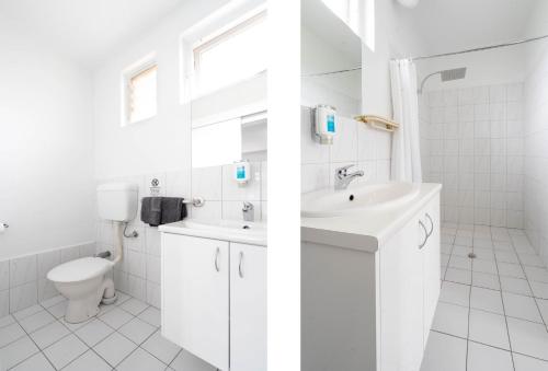 a white bathroom with a sink and a toilet at City West Motel in Adelaide