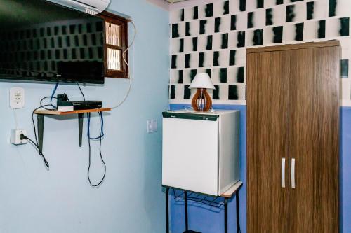 a room with a television and a small refrigerator at Pousada Cachoeira da Fumaça in Palmeiras