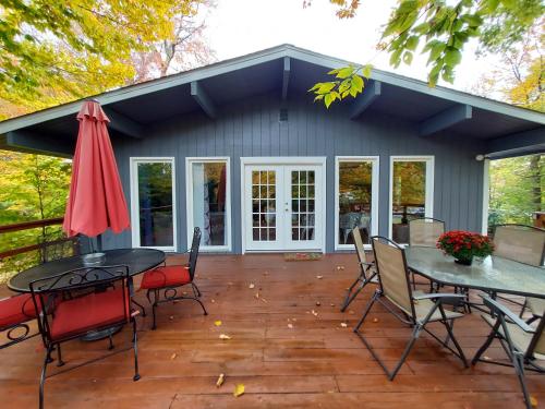 a patio with tables and chairs and a house at Chic and Stylish home Hot tub,4 bedrooms, game movie room, firepit, arcades, playground on site 2 min walk from pool and lake in Tobyhanna