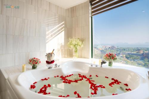 a white bath tub with red flowers in the middle at Ha Long Dream Hotel in Ha Long