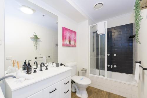 La salle de bains blanche est pourvue d'un lavabo et de toilettes. dans l'établissement City skyline views with swimming pool!, à Melbourne