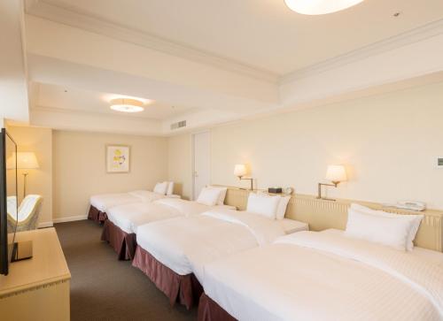 a row of beds in a hotel room at SHIROYAMA HOTEL kagoshima in Kagoshima