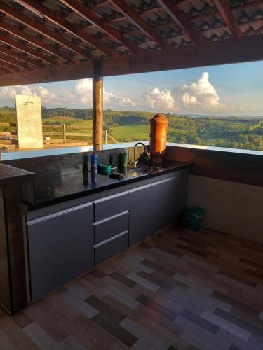 a kitchen with a sink and a large window at Chácara do Mirante in São Sebastião do Paraíso
