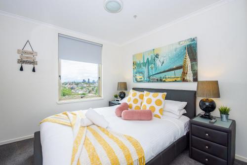 a bedroom with a large bed with a window at City skyline views with swimming pool! in Melbourne