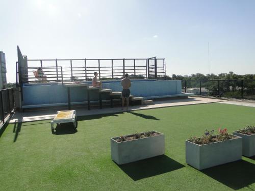 a man standing on top of a roof at Departamento en Terrazas al Green in Rosario