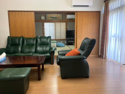 sala de estar con sofá, sillas y mesa en season guest house, en Tokio