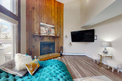 a living room with a blue couch and a fireplace at Mountainside Oasis in Avon