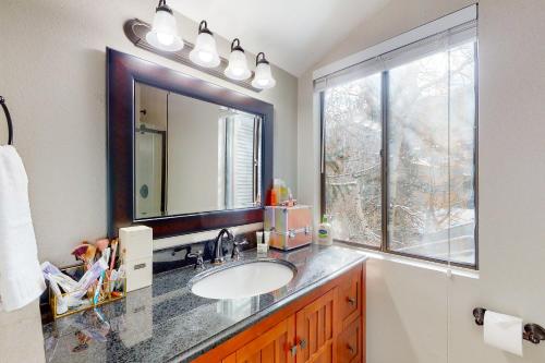 łazienka z umywalką, lustrem i oknem w obiekcie Mountainside Oasis w mieście Avon