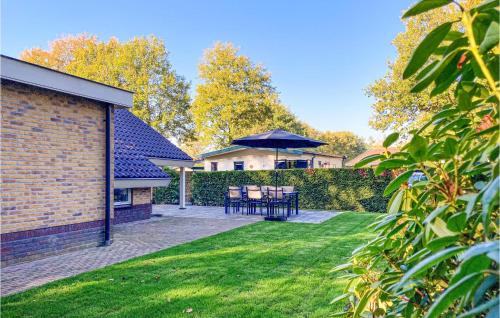 a patio with tables and an umbrella in a yard at Nice Home In Putten With Kitchen in Putten