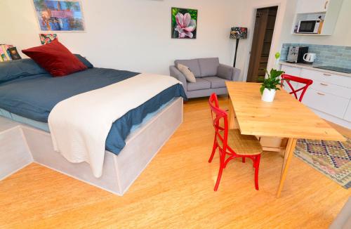 1 dormitorio con cama, mesa y cocina en Studio with Rural views, en Goonellabah